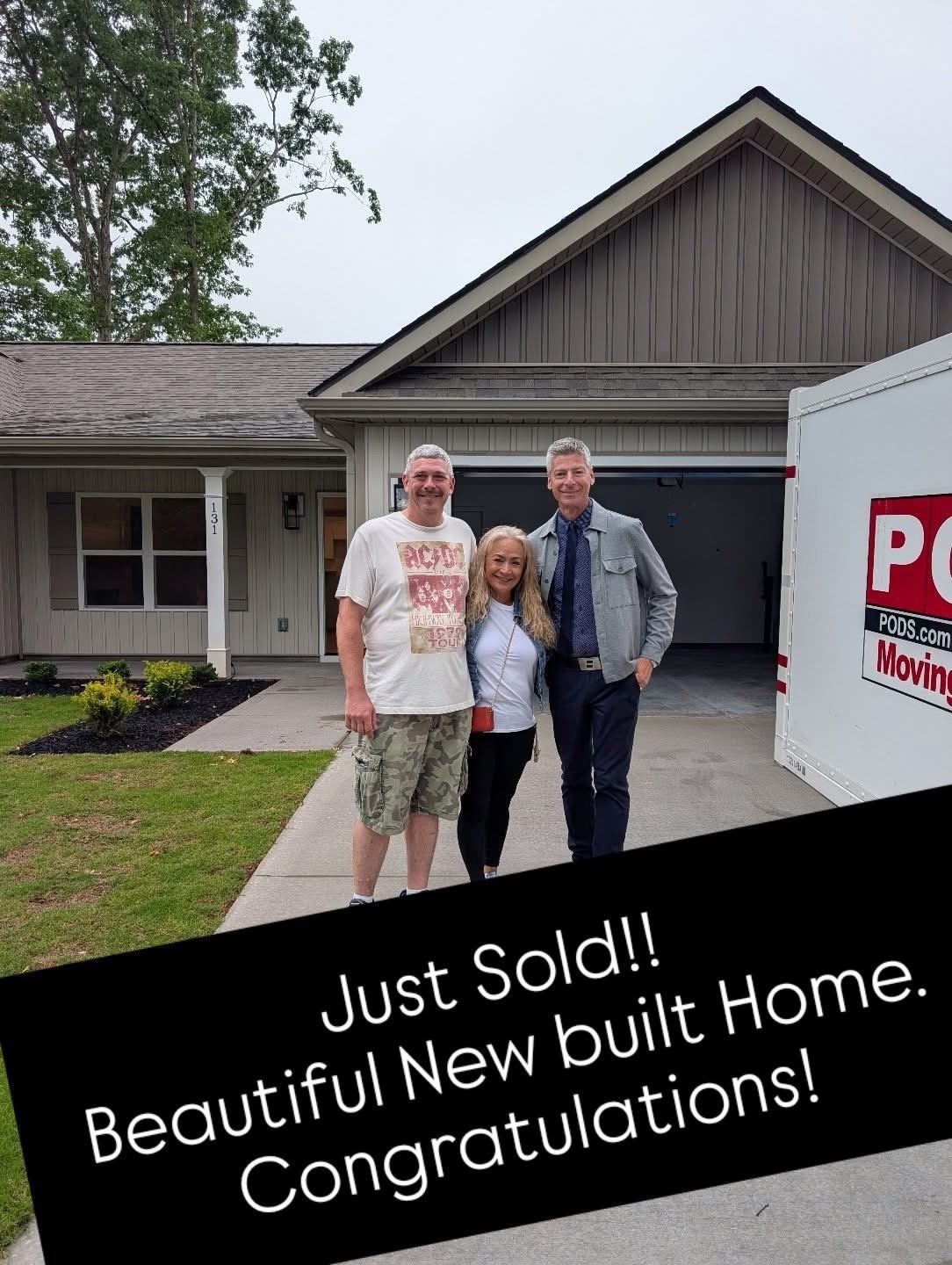 Three people celebrating in front of a home